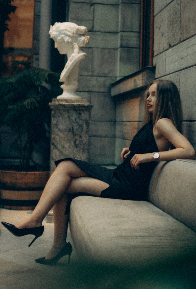 A Woman In A Halter Top Dress Sitting On A Couch