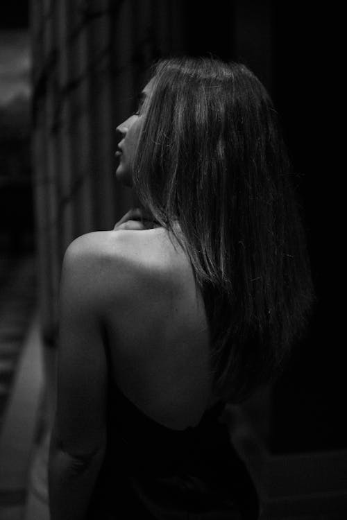 Free A Grayscale of a Woman in a Backless Dress Stock Photo