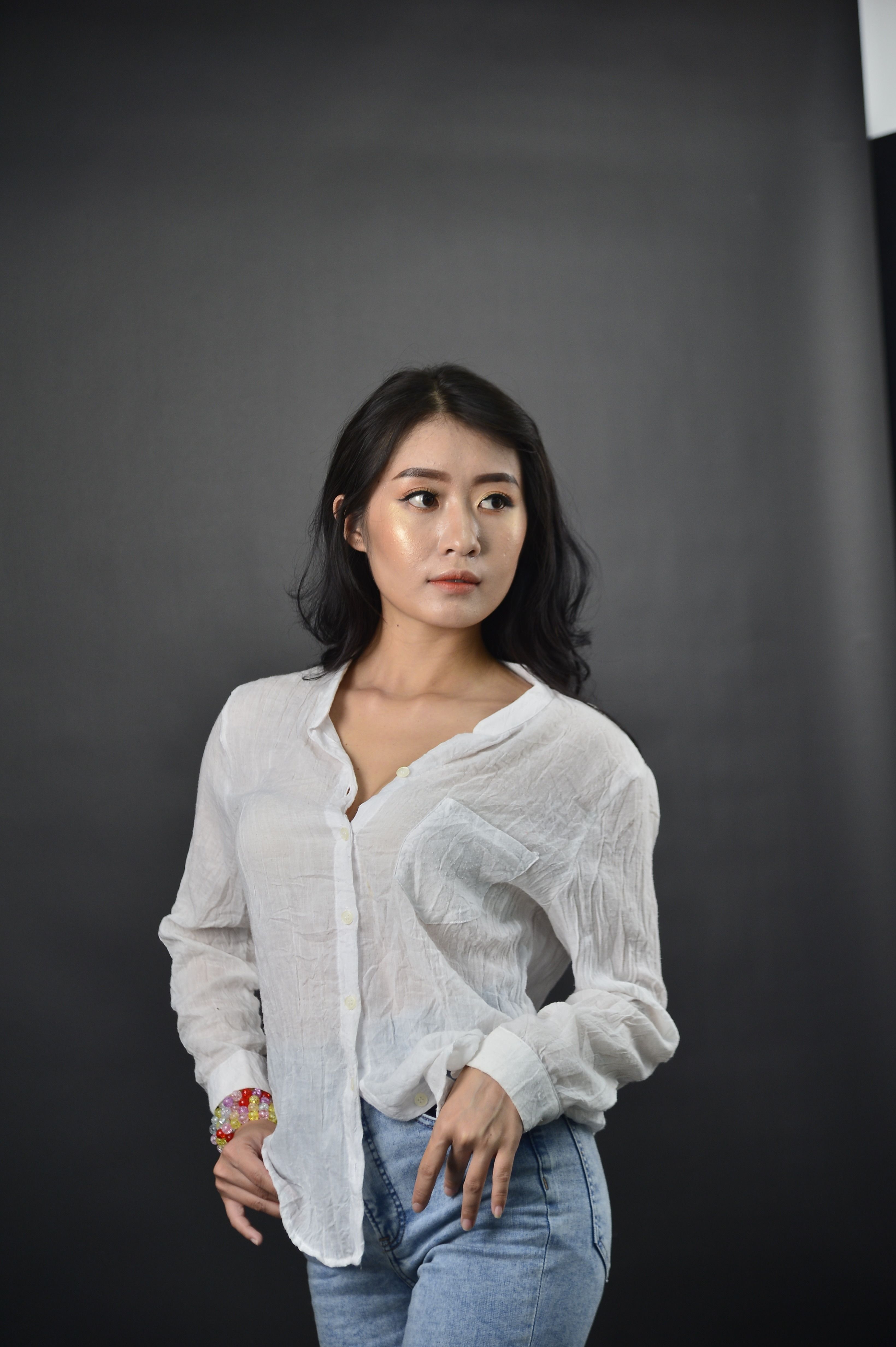A Woman in White Long Sleeve Shirt Posing in the Studio · Free Stock Photo