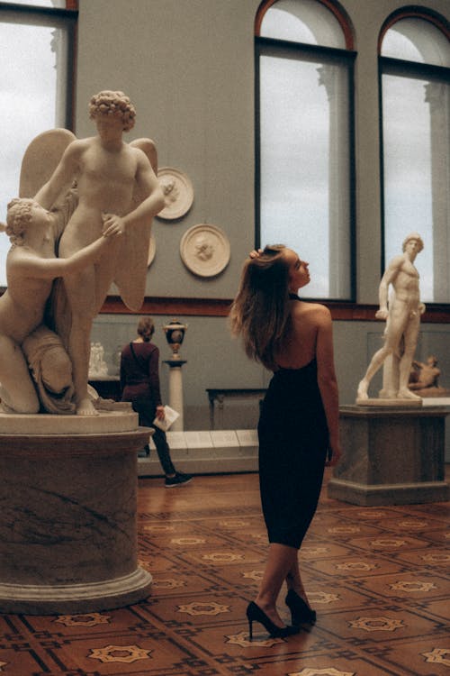 A Woman Wearing a Backless Dress in a Museum