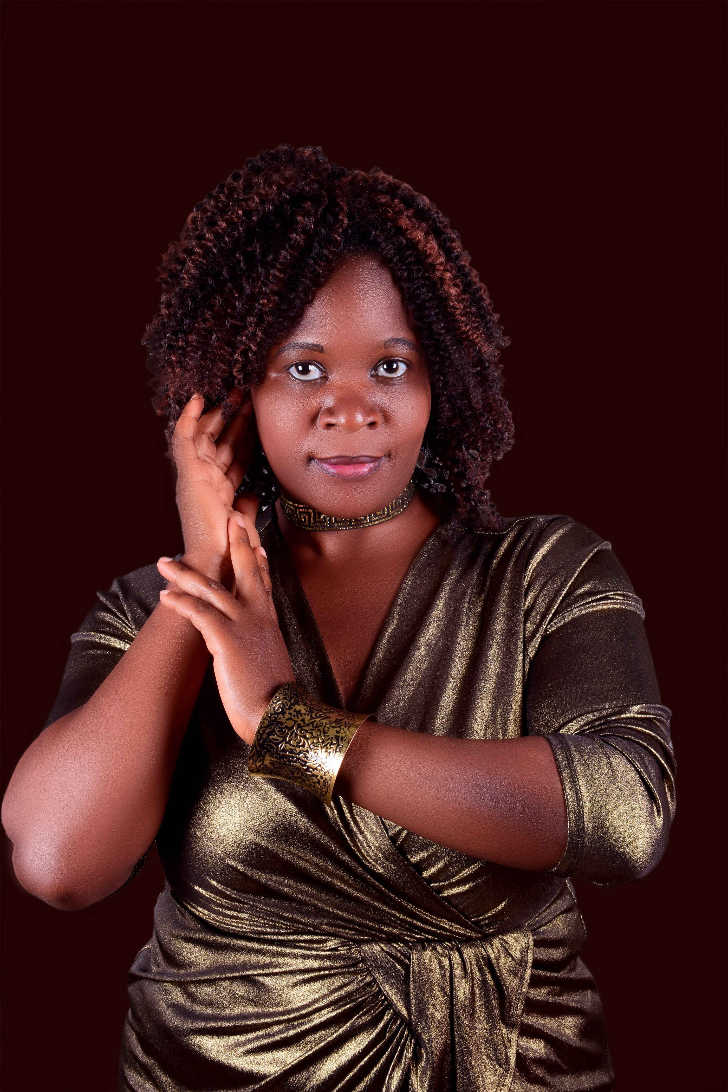Portrait of an African woman with curly hair posing elegantly in a studio.