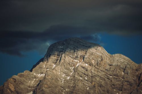 Free Captivating view of a rugged mountain peak in San Martino, Italy under dark storm clouds. Stock Photo