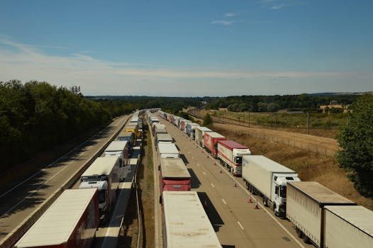 Aerial view of heavy traffic with trucks on an English highway under blue skies.
