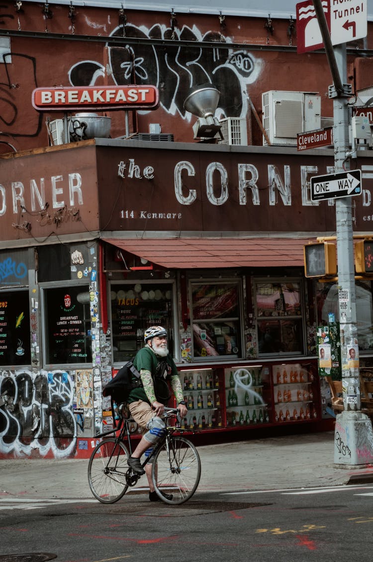 Elderly Man Riding Bike In City