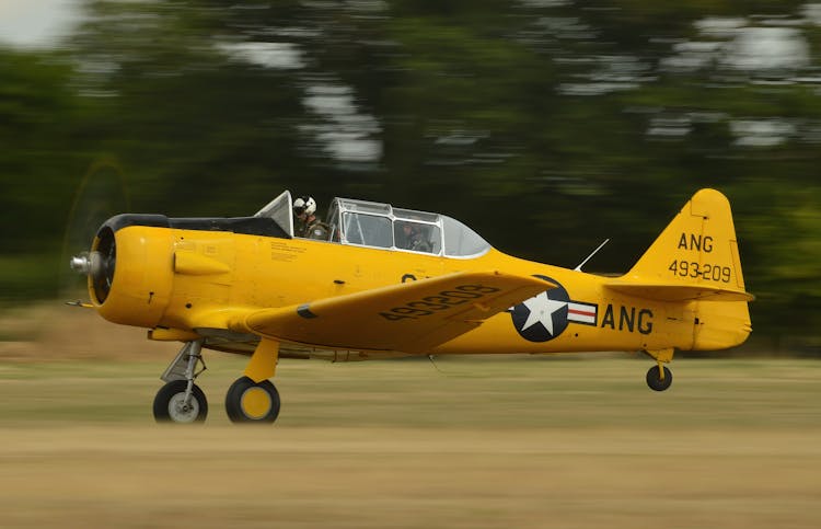 A Person Flying A Yellow Airplane