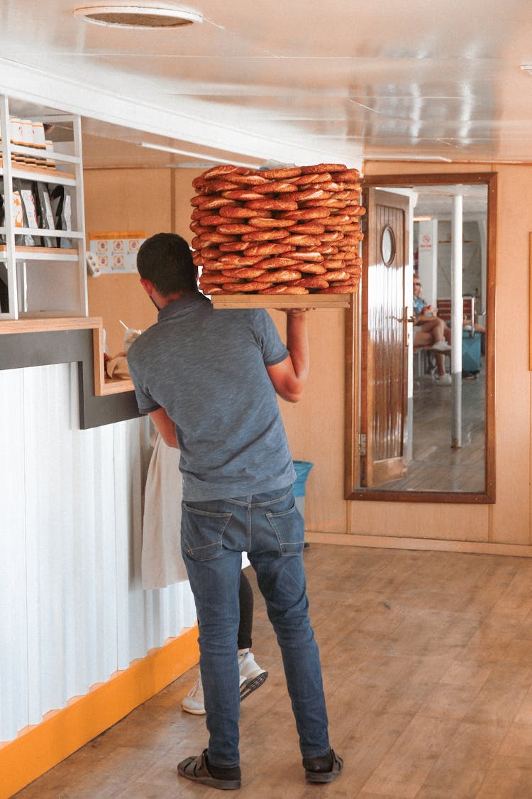 A Man Carrying A Stack Of Simit Bread