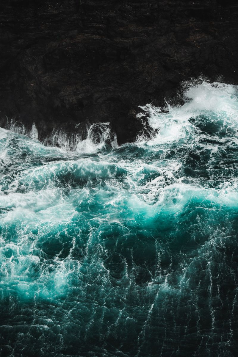 Powerful ocean waves crashing on the rocky coast of the Faroe Islands, showcasing nature's raw beauty.