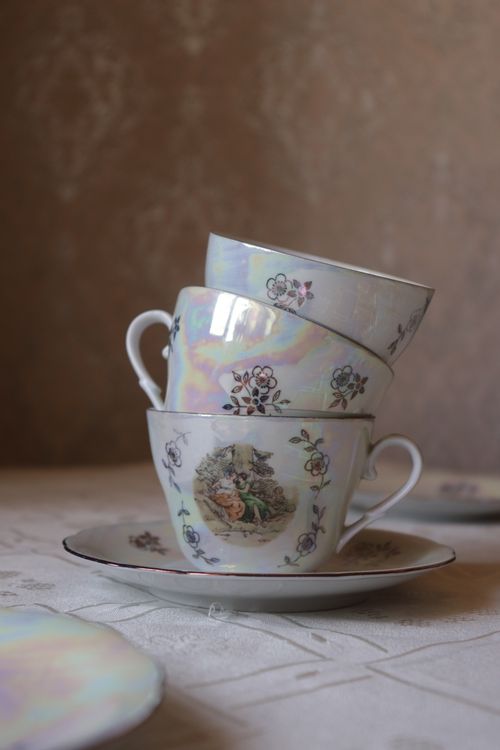 Free A vertical shot of vintage teacups with floral patterns stacked elegantly on a saucer. Stock Photo