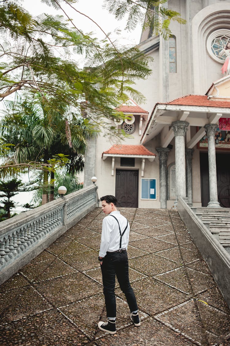 A Man Wearing A White Dress Shirt And Black Pants On A Driveway