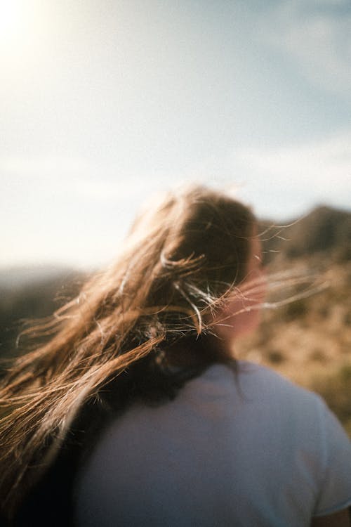 Free Woman in White Shirt Standing on Brown Grass Field Stock Photo