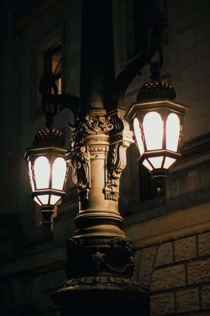 A classic ornate street lamp glowing warmly against a night backdrop, exuding vintage charm.