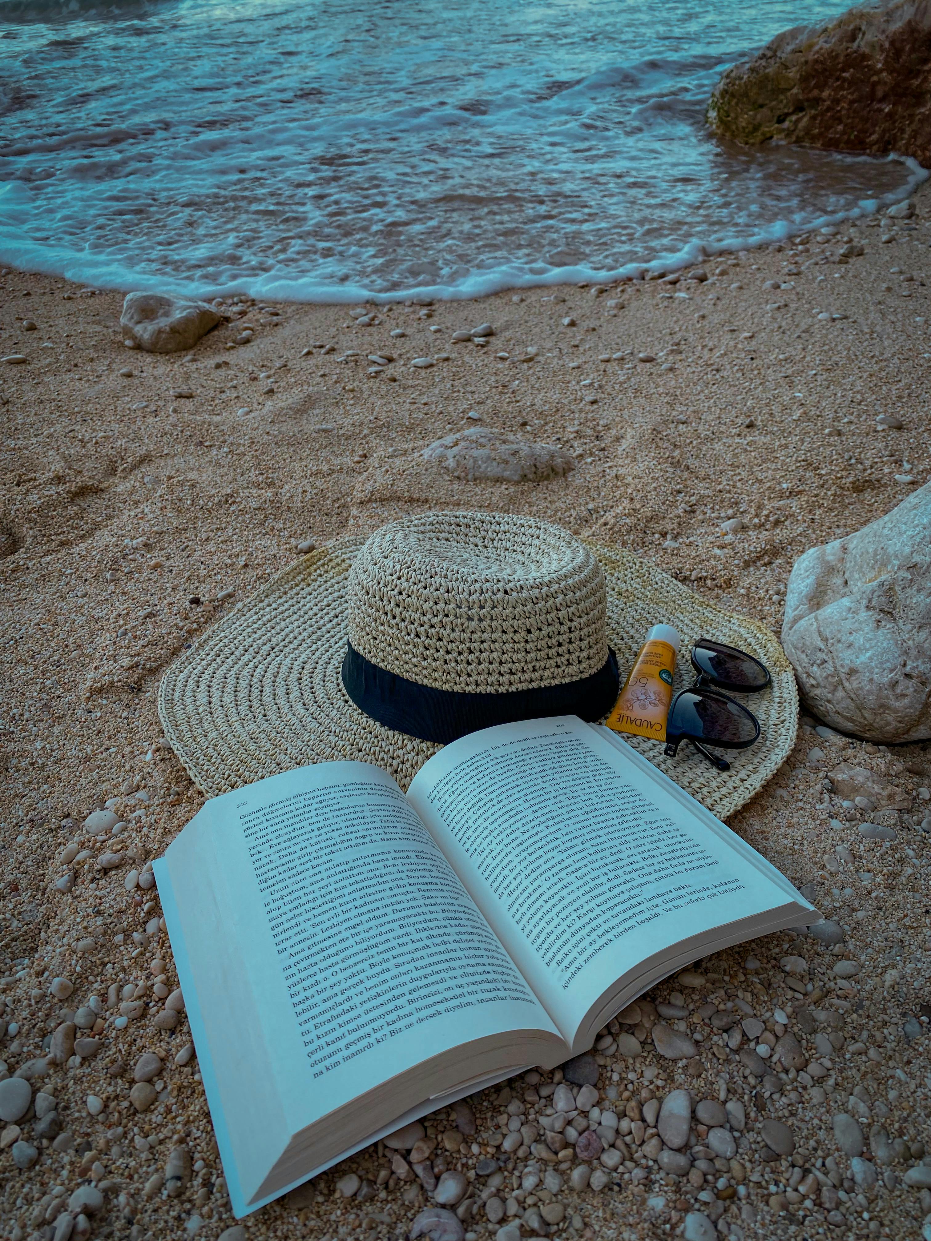 Premium Photo | Young asian man with sunglasses reading on the beach