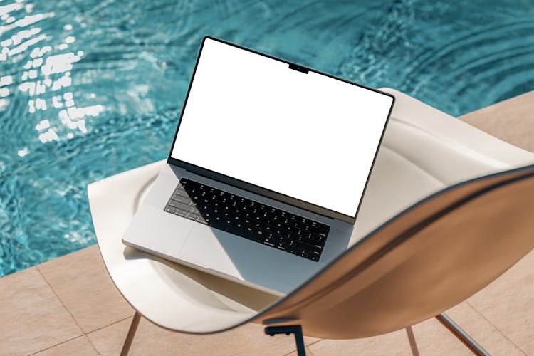 A Laptop On A Chair By The Swimming Pool