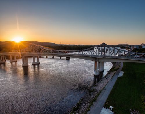 Free Aerial view of a bridge spanning the Mississippi River at sunset, capturing the vibrant sky. Stock Photo