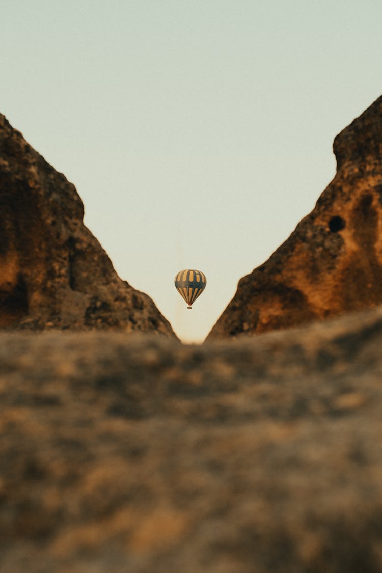 Hot Air Balloon Ascending Above Valley