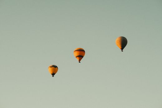 Hot air balloons rising into a pale sky — Sami Aksu on Pexels