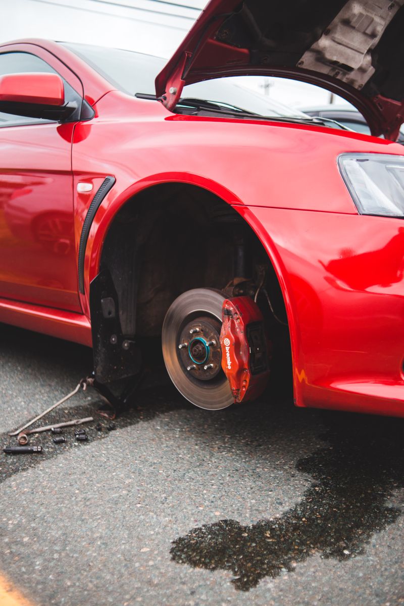 Mechanic inspecting brake pad and rotor during a vehicle service