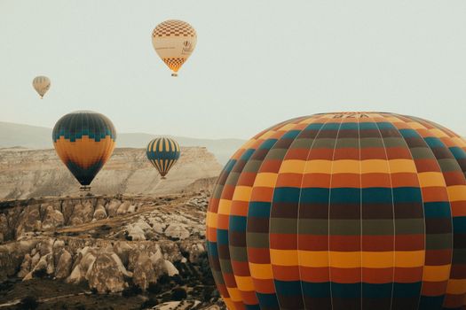 Hot air balloons floating over Cappadocia's unique landscape, a vibrant aerial view.