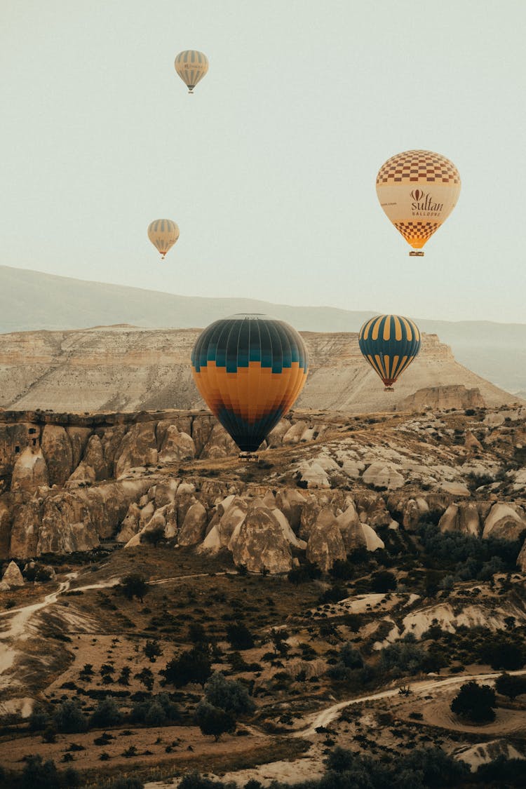 Hot Air Balloons Flying Above Mountain Valley