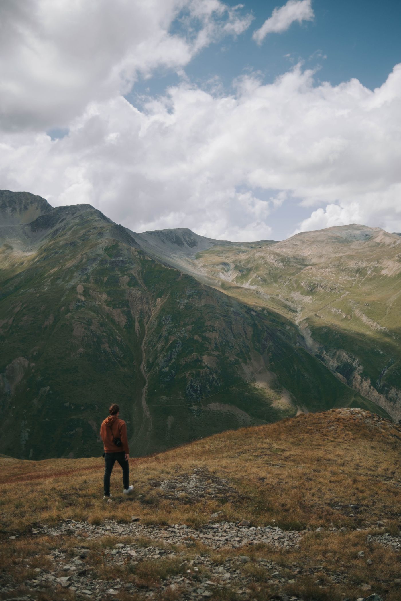 Un escursionista in cima alla montagna contempla il paesaggio