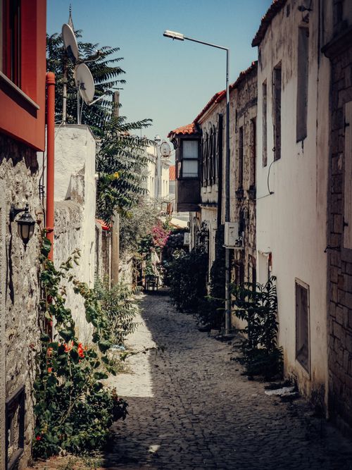 Free Explore a quaint cobblestone alley lined with historic buildings and satellite dishes. Stock Photo
