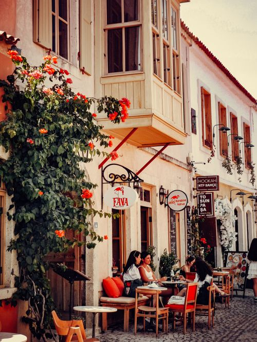 Free Cozy outdoor café with vibrant flowers in a bustling street setting. Stock Photo