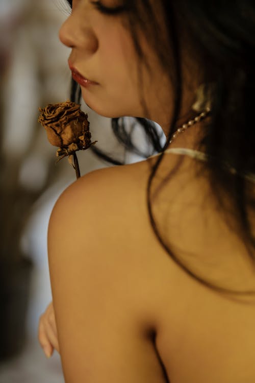 A Close-Up Shot of a Woman with a Dried Rose