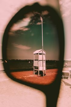 Unique view of a beach lifeguard stand through sunglasses on a summer day.