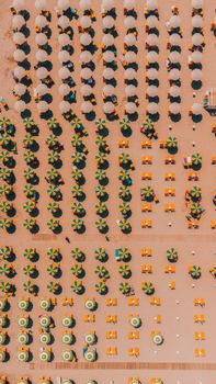 Bird's-eye view of vibrant umbrellas and loungers on Igea Marina beach, Italy. Perfect summer vibe.