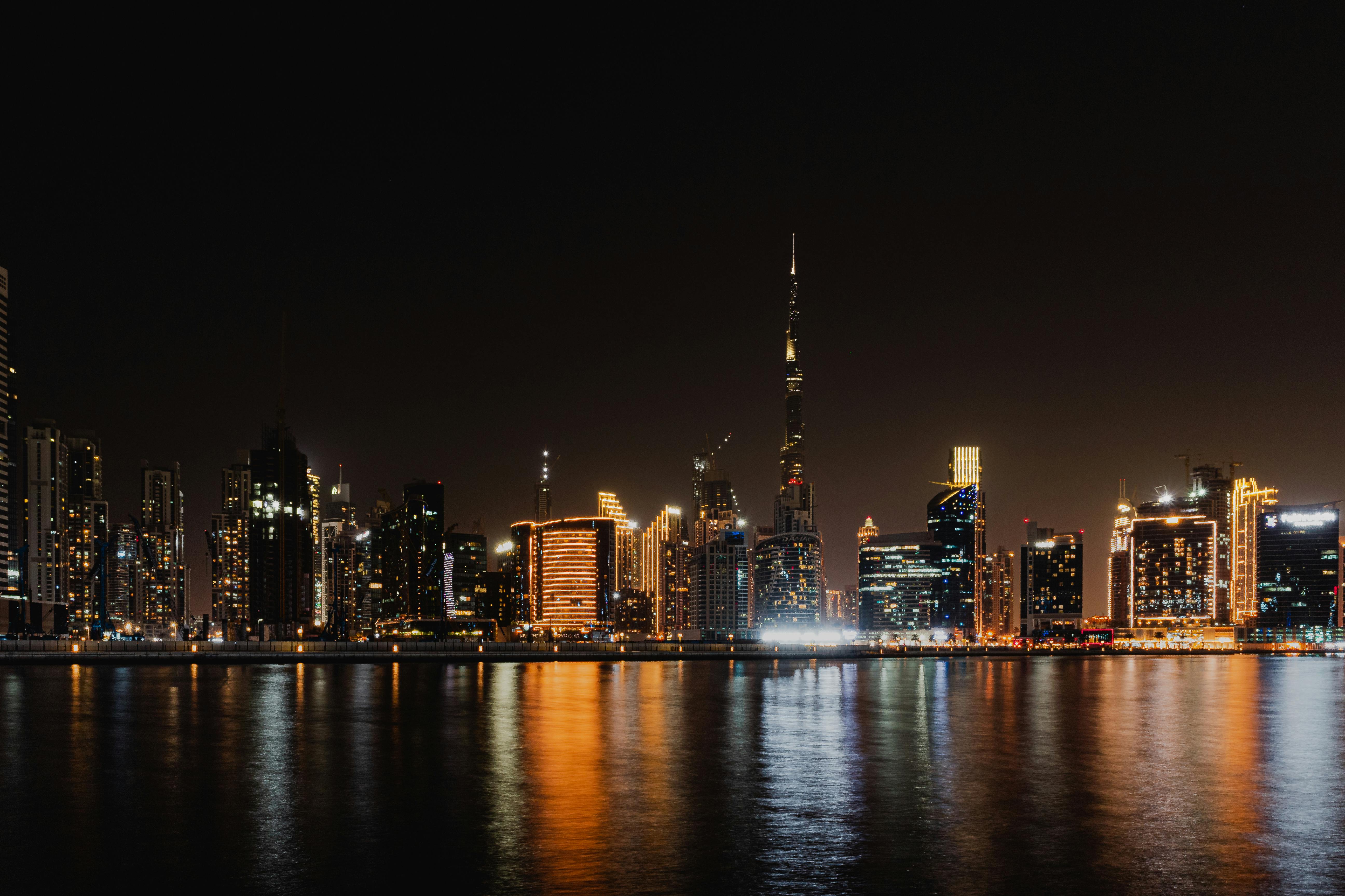 Stunning view of Dubai's skyline with Burj Khalifa reflecting in the water at night.