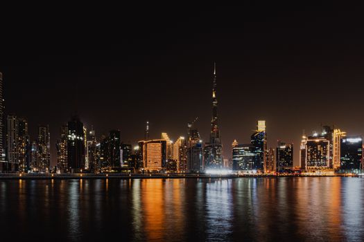 Stunning view of Dubai's skyline with Burj Khalifa reflecting in the water at night.