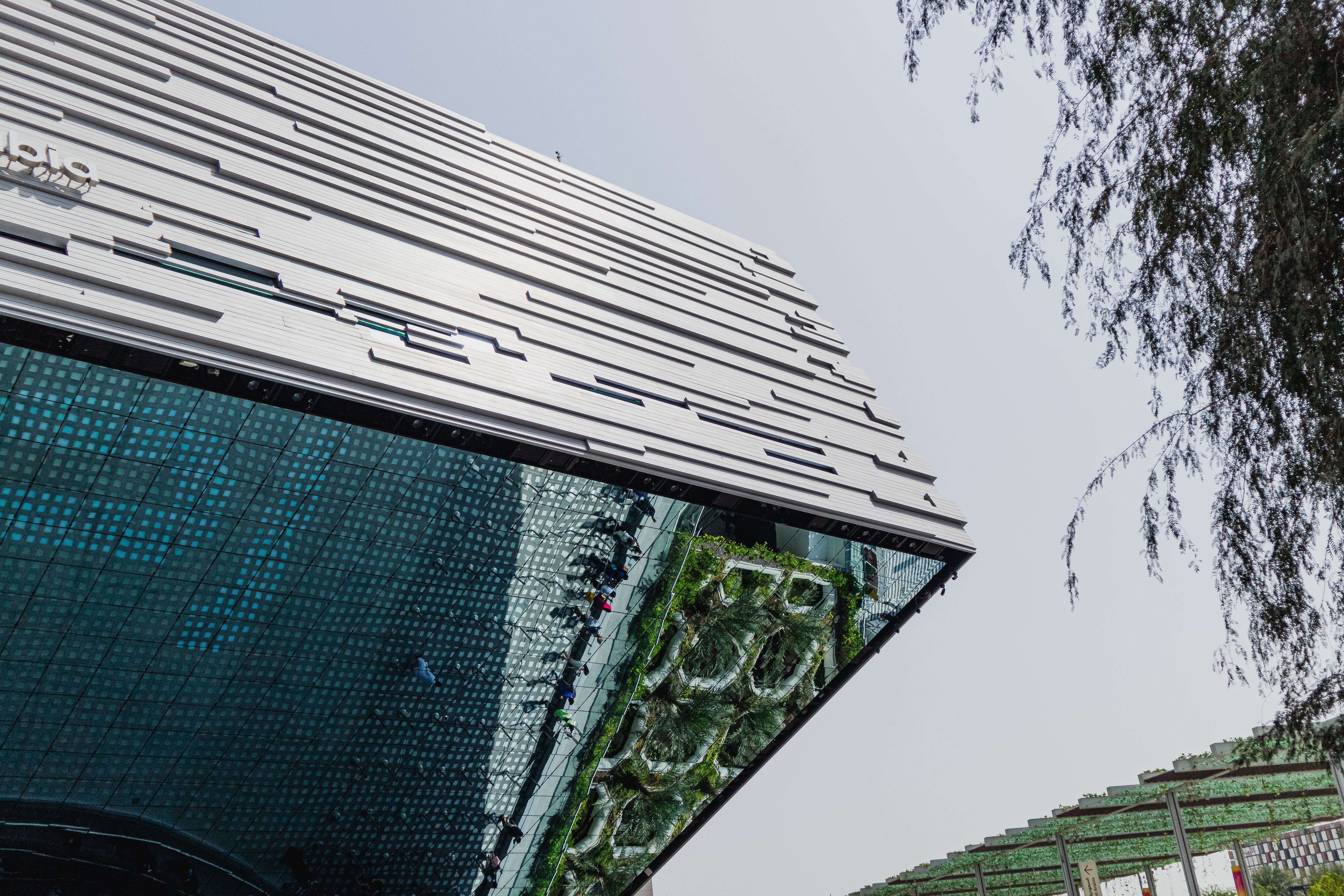 Low angle view of a modern building with reflective glass and unique design features.