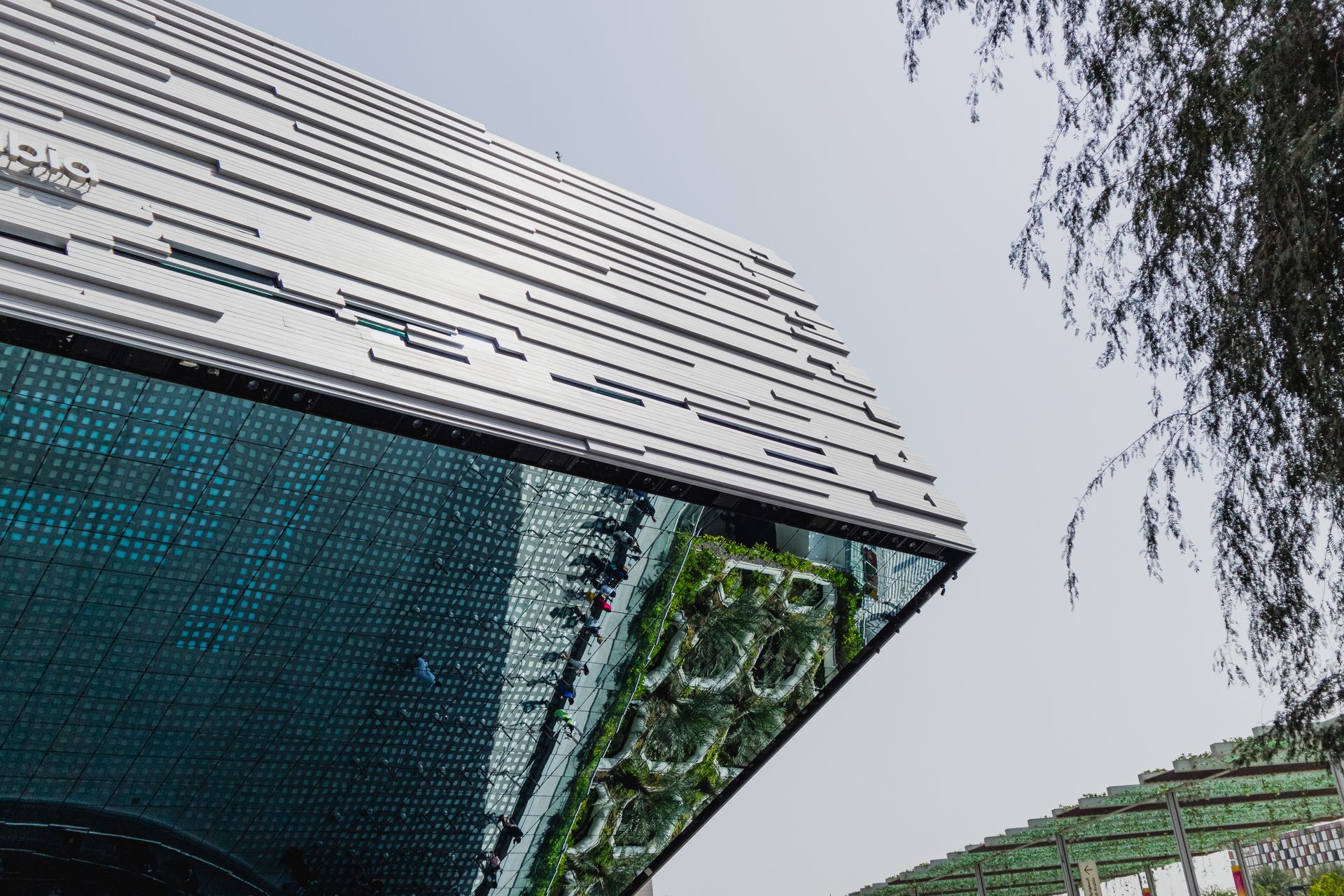 Low angle view of a modern building with reflective glass and unique design features.