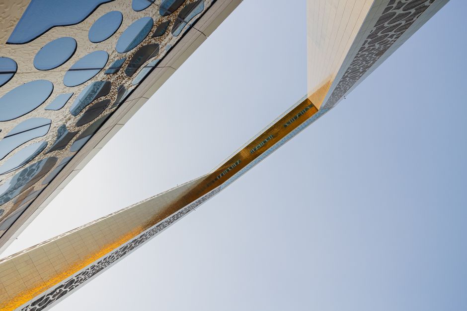 Low angle view of the iconic Dubai Frame with intricate patterns against a clear blue sky.
