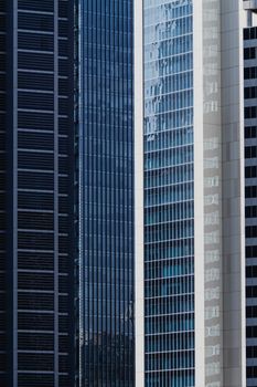 Vertical shot of modern skyscrapers with reflective glass facades, emphasizing contemporary city architecture.
