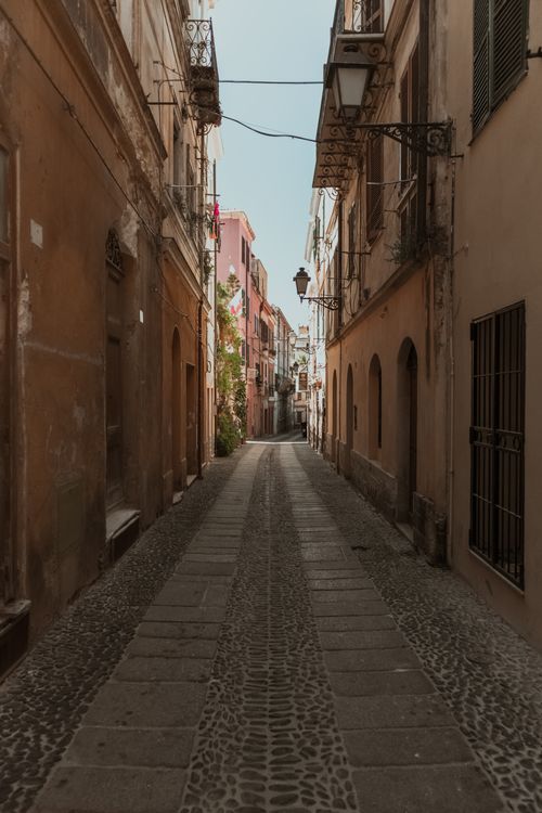 Free Explore a picturesque narrow alley lined with historic buildings and a cobblestone path. Stock Photo