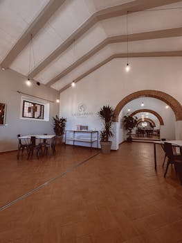 A spacious and elegant restaurant interior with contemporary design and arched ceilings.