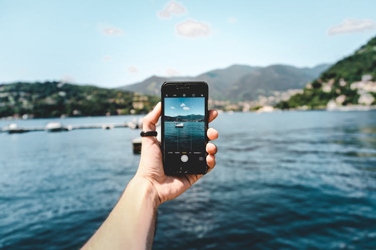 Person Photographing Bay With Smartphone