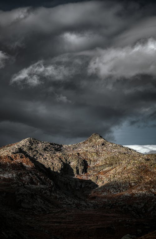 Free Brown Mountain Under Dark Clouds and Gray Sky Stock Photo