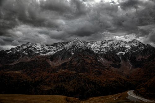 Free A breathtaking view of snowcapped mountains under a dramatic cloudy sky in Airolo, Switzerland. Stock Photo