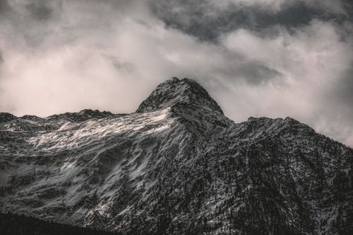 Free A breathtaking view of a snow-covered mountain peak under dramatic clouds in Rossura, Switzerland. Stock Photo