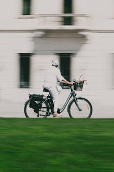 A senior woman enjoying a leisurely bike ride through a city setting on a sunny day.