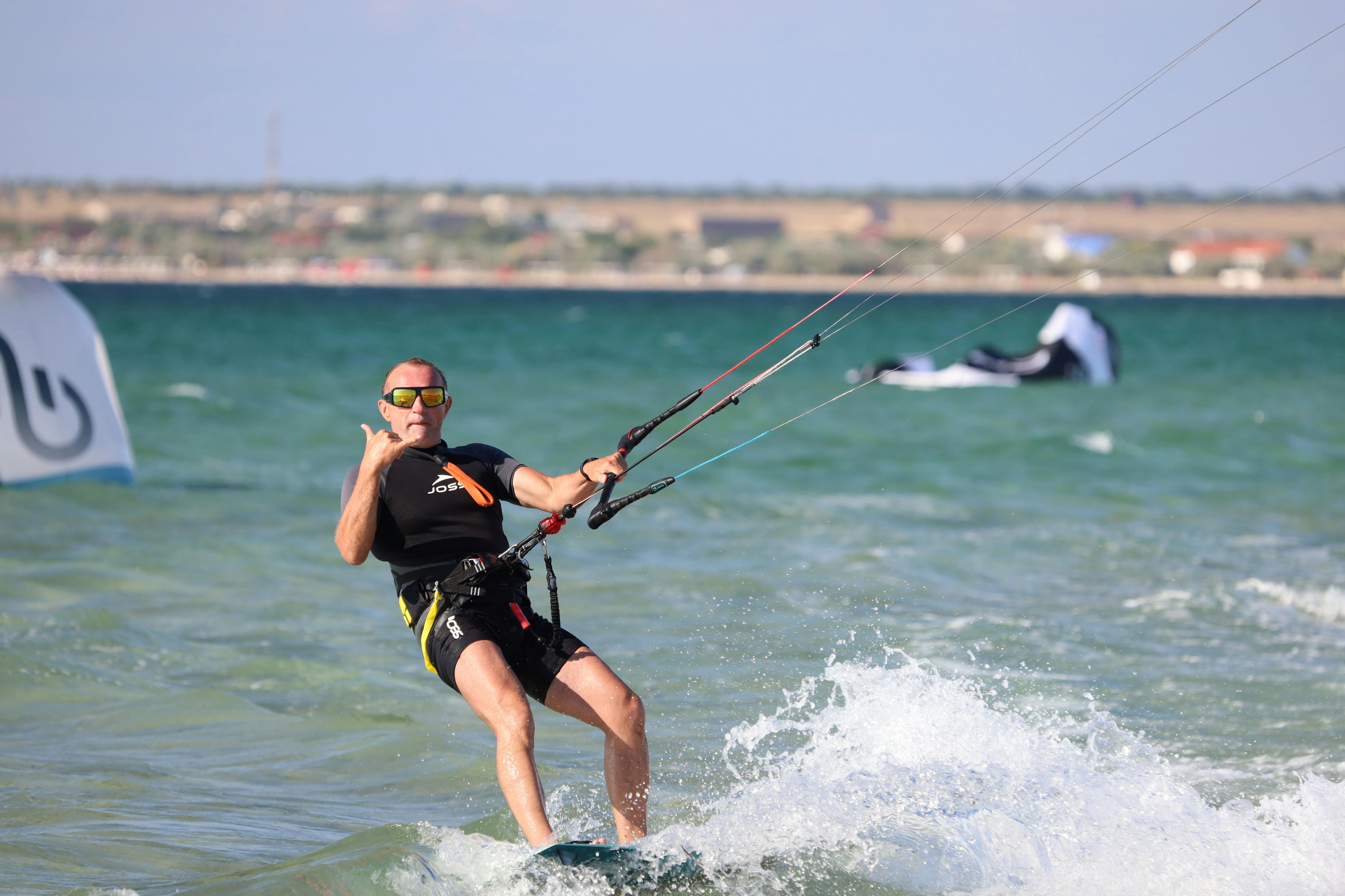 Man in Black Wetsuit Riding on a Kiteboard · Free Stock Photo