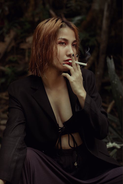A Woman in Black Blazer Smoking Cigarette