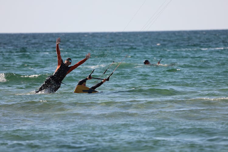 Men Kitesurfing In Ocean