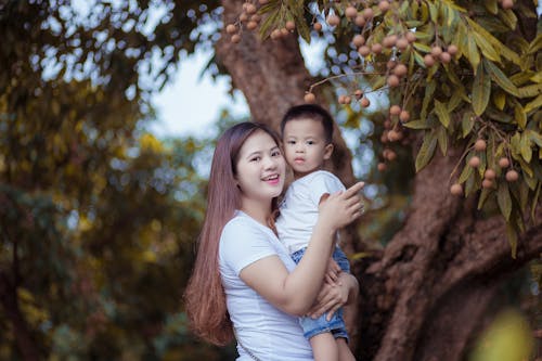 Femme, Porter, Enfant, Debout, Près, Arbre