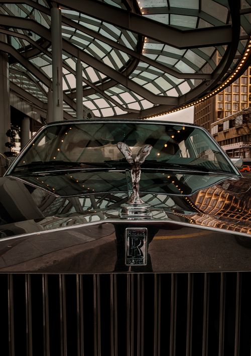 Free Close-up view of Rolls Royce emblem reflecting city architecture, showcasing luxury in Vancouver. Stock Photo