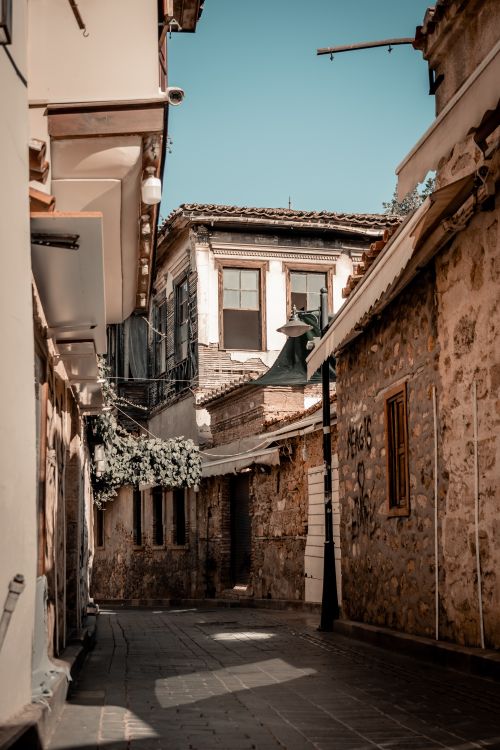 Free A picturesque old town alley with rustic stone buildings under a clear sky. Stock Photo