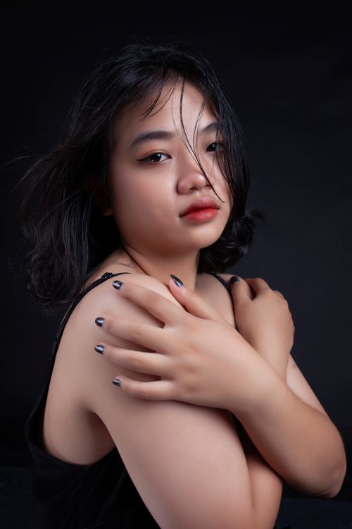 Free Striking portrait of a woman with an emotional gaze against a dark backdrop, conveying deep emotions. Stock Photo