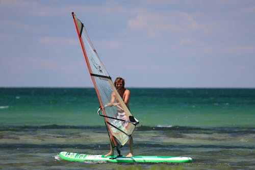 Shirtless Man Windsurfing